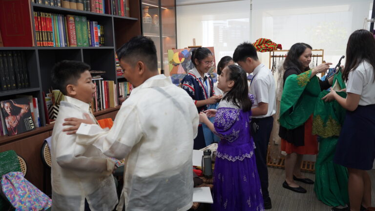 Students trying out Filipiniana and Barong, the national dress of the Philippines.