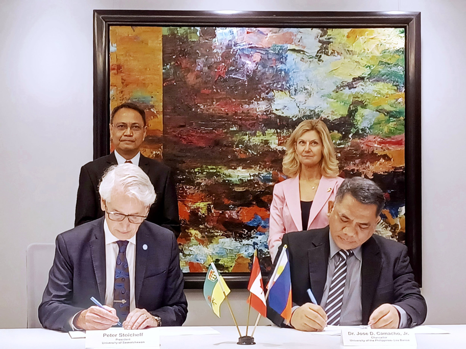 Dr. Peter Stoicheff (left) President of the University of Saskatchewan (USask) and Dr. Jose D. Camacho, Jr. (right), Chancellor, University of the Philippines Los Baños signs the MOU on Academic and Research Cooperation on 20 February 2023. Behind them were witnesses Ms. Cheryl Hamelin, Vice President, University Relations of USask and Dr. Nathaniel C. Bantayan, Vice Chancellor for Research and Extension, UPLB.