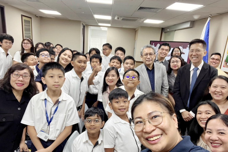 The faculty and students pose for a groufie with the Embassy officers.